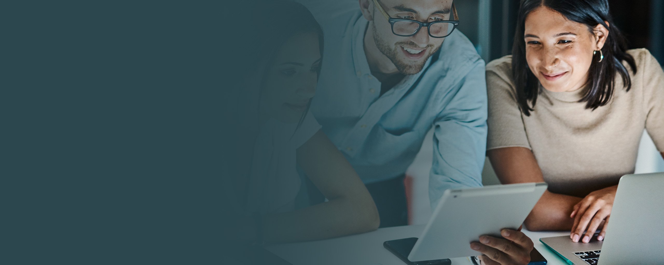 Drei Personen im Business-Kontext beugen sich über ihre Arbeit